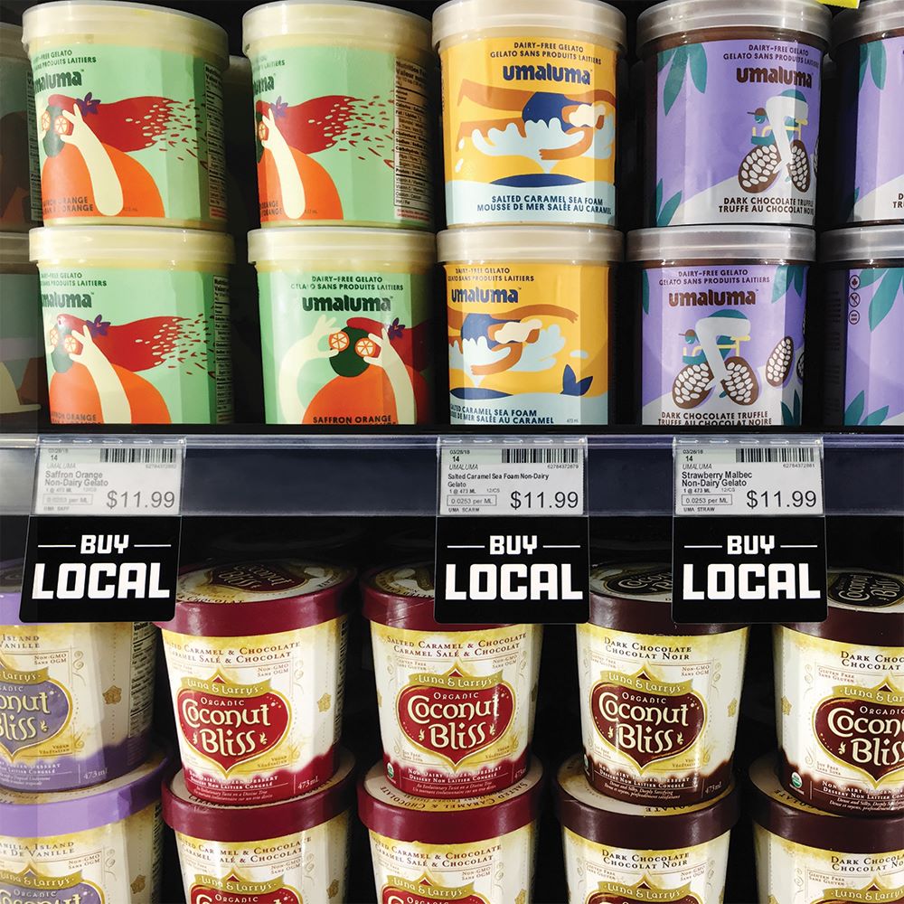 A grocery store freezer with ice cream and a shelf edge with a ClearGrip ticket molding and "Buy Local" ShelfTalkers.