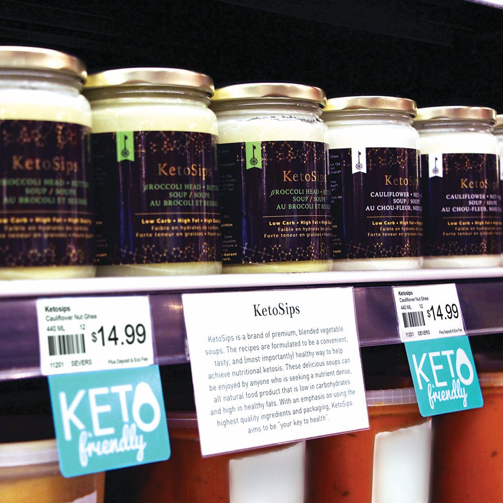 Jars of keto soups on a shelf edge with 'Keto friendly' Shelftalkers installed into the ticket molding below and perforated sign and label paper inserted.