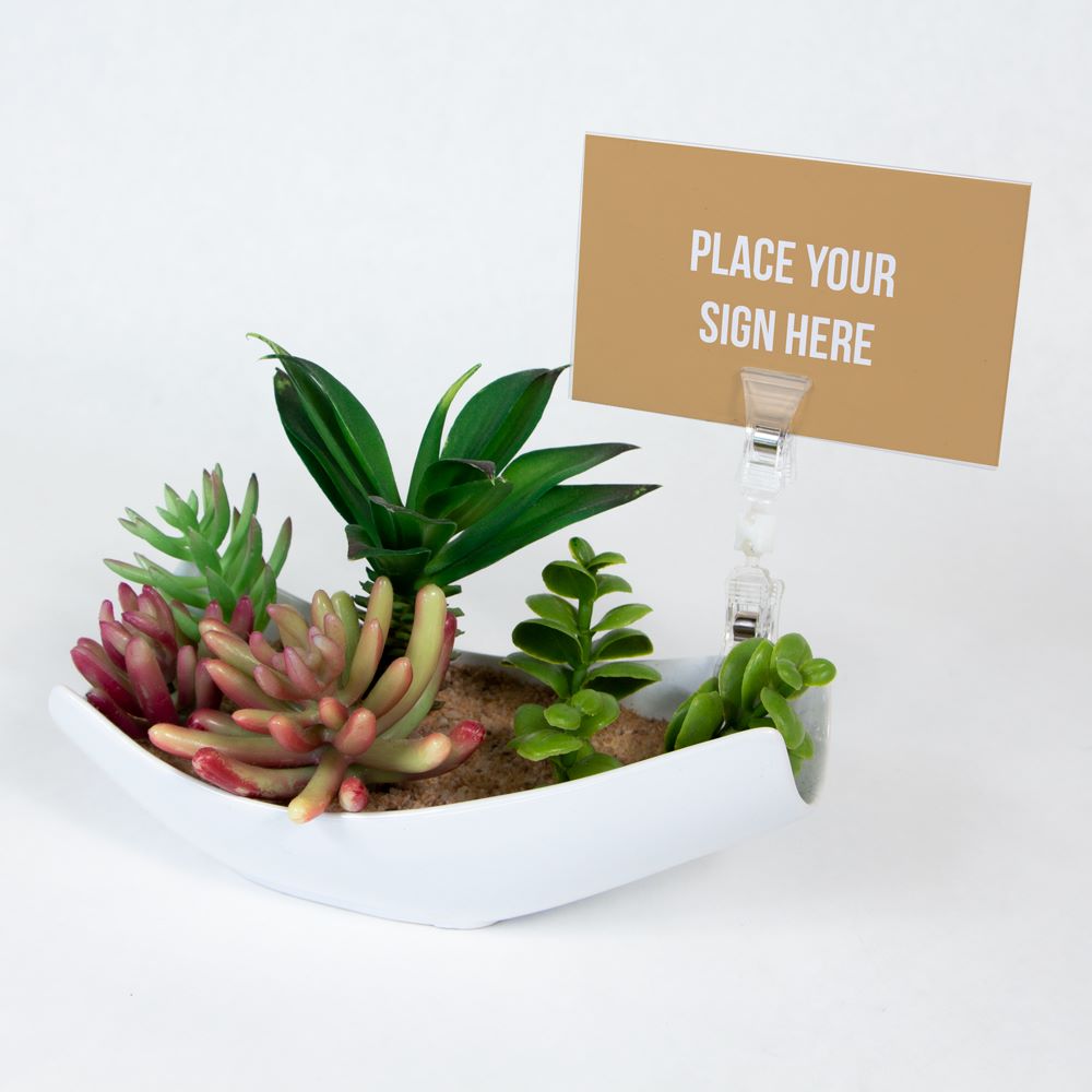 The TwistKlip Double Small Clip clipped onto the edge of a small plant pot, holding a sign
