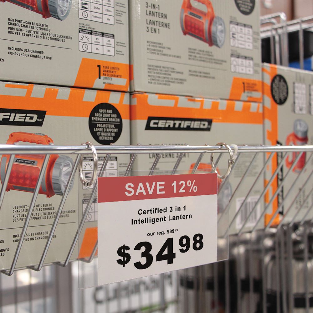 A wire fence basket in a hardware store with a one fold sign protector with metal rings displaying the price of products inside