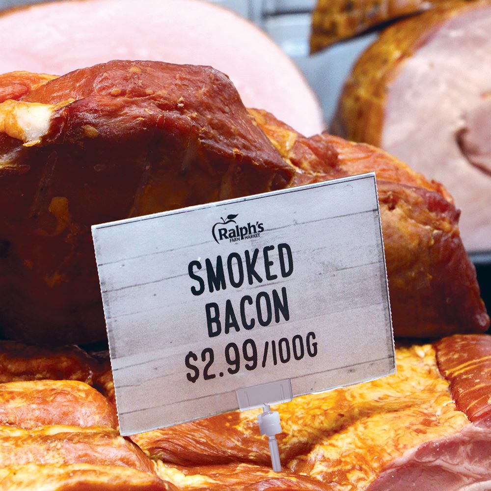 The TwistKlip Deli Pin with Small Card Holder Sign Holder pierced into a slab of smoked bacon, holding a large price sign.