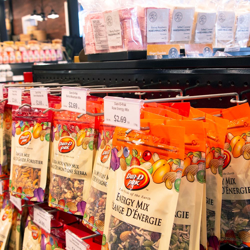 Bags of trail mix hanging from scanning hooks with ClearVision T-Wire or Small Plate, Swing-Up Label Holders displaying price tickets