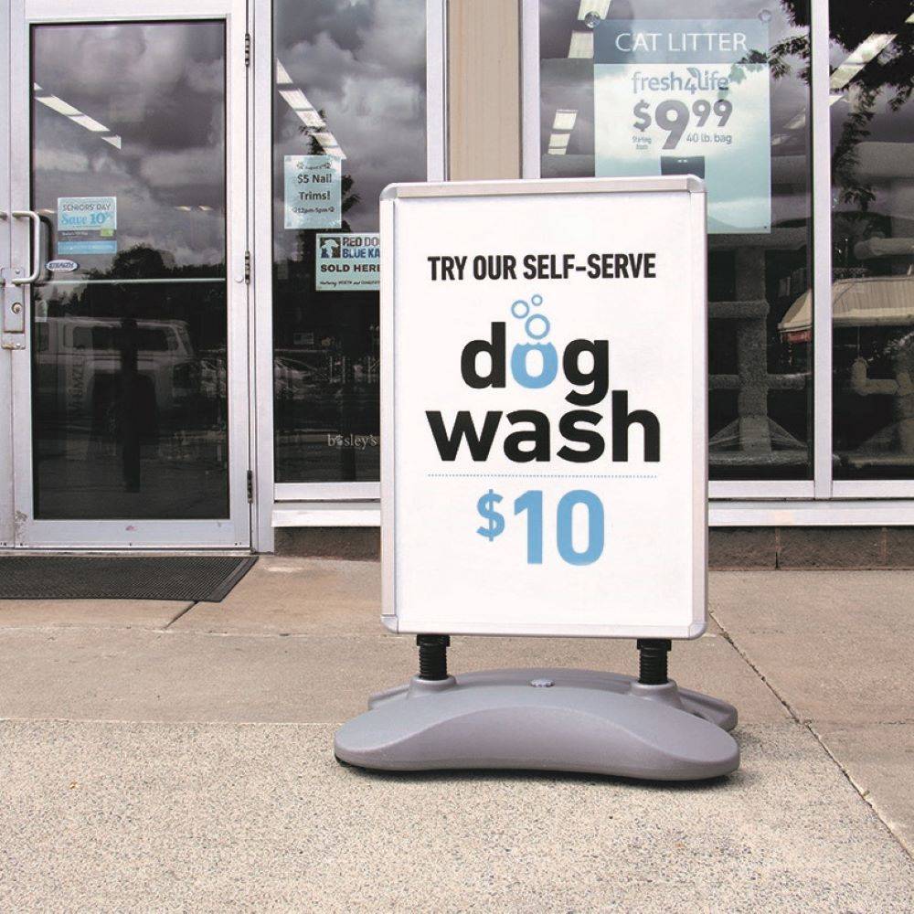 An outdoor WalkTalker in front of a pet store display a sign for dog washing