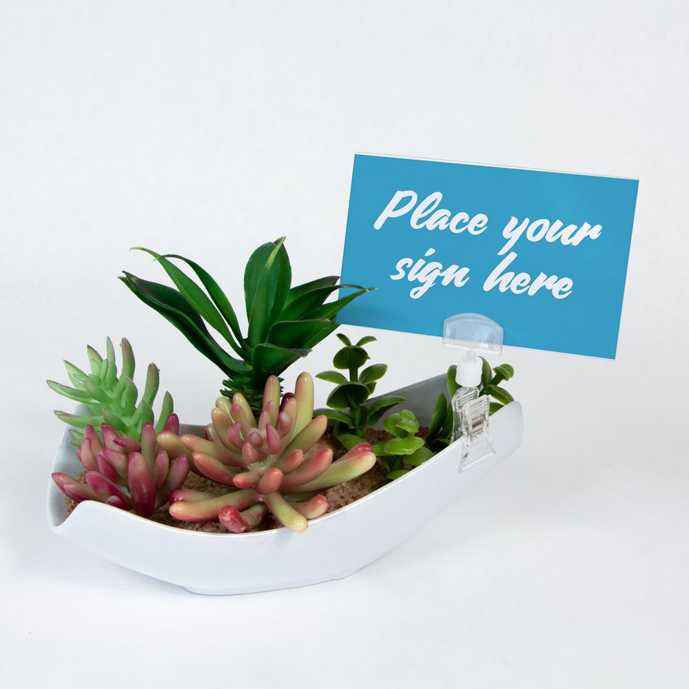The TwistKlip Card Holder with Small Clip clipped onto a small plant pot and holding a sign