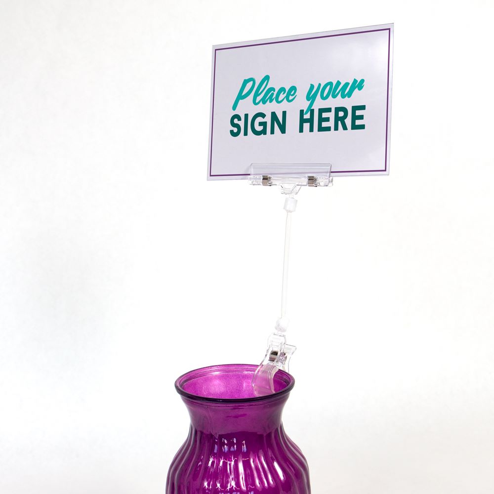 The TwistKlip Display Clip with Large Clip, Long Extension clipped onto a vase and holding a large sign