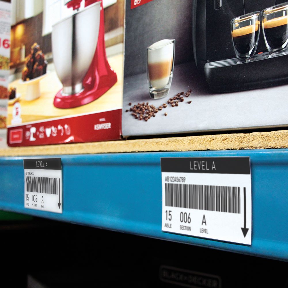 A warehouse shelf edge with Two Fold with Magnetic Tape Sign Protectors holding barcodes labels